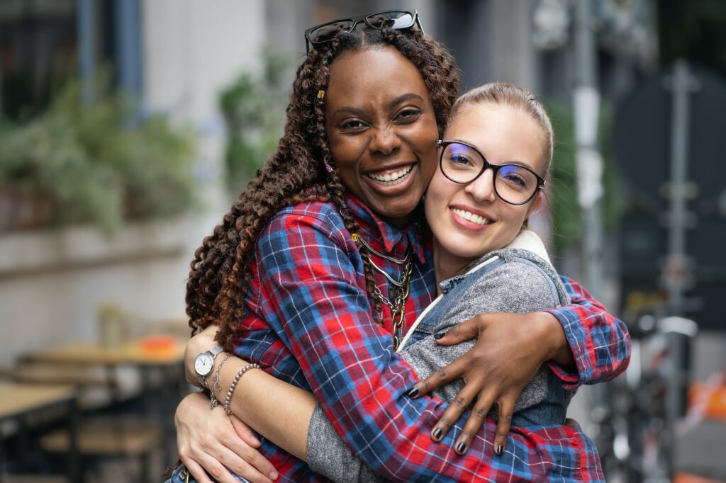 Portrait of two interracial best friends girls hugging together