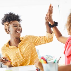 mother teaching daughter and helping with homework at home, daughter giving high five to father